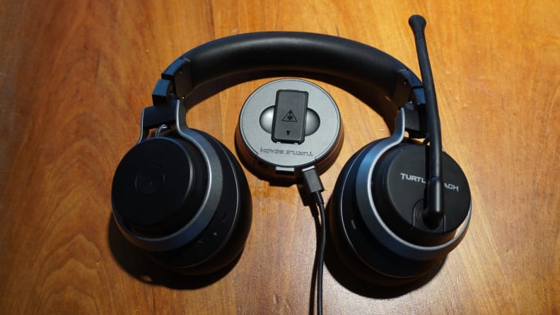 The Turtle Beach Stealth Pro and its USB base station on a wooden desk surface.