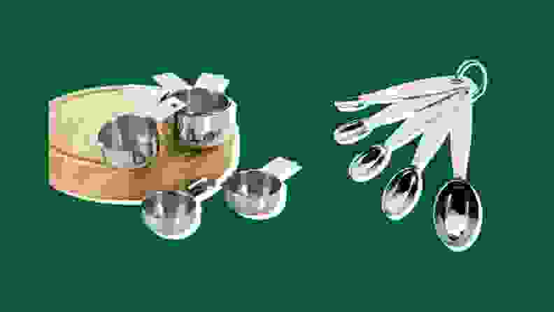 Stainless steel measuring cups and spoons on a green background
