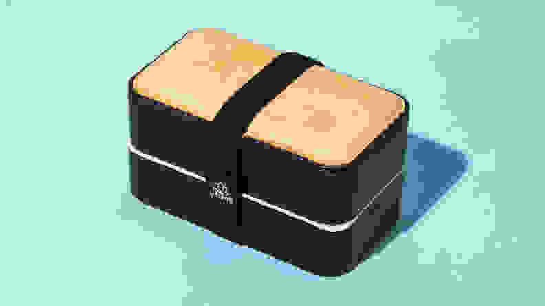 A black and beige Bento box securely fastened.