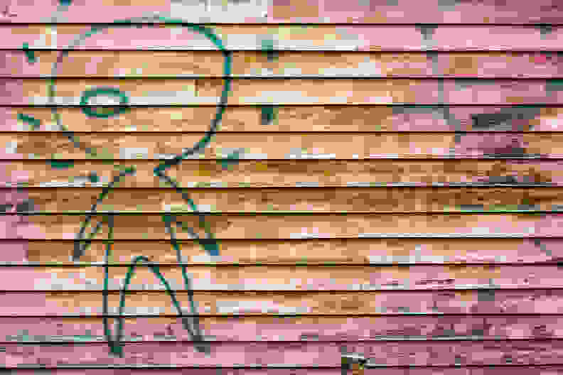 Alien graffiti on rich colored wooden wall.