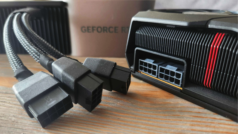 Angled shot of the Nvidia GeForce RTX 4080's adapter with graphics card and its four extra cables.