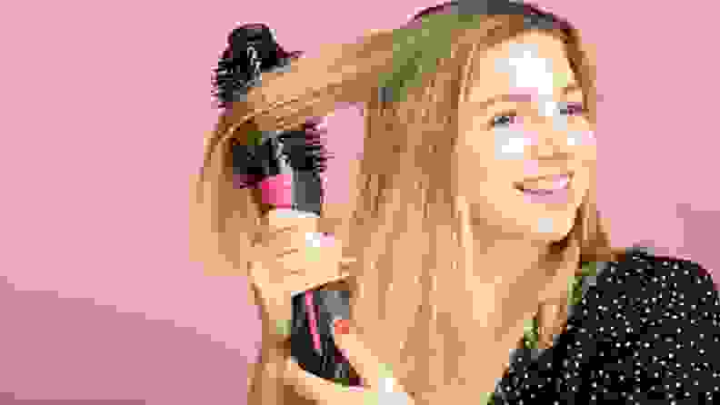 Image of person brushing their hair with hairstyling tool