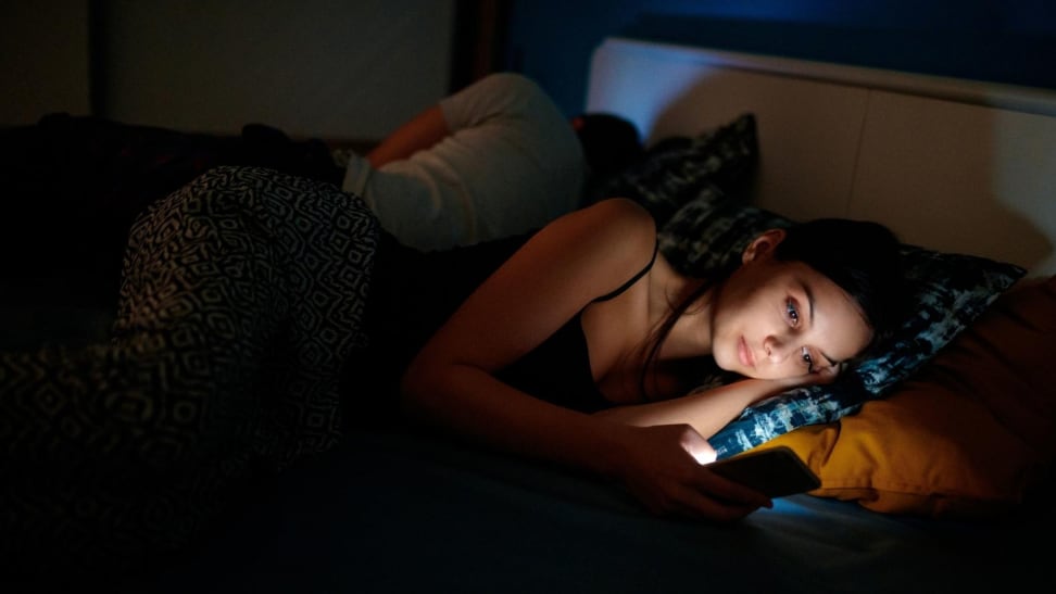 A woman in bed with her phone.