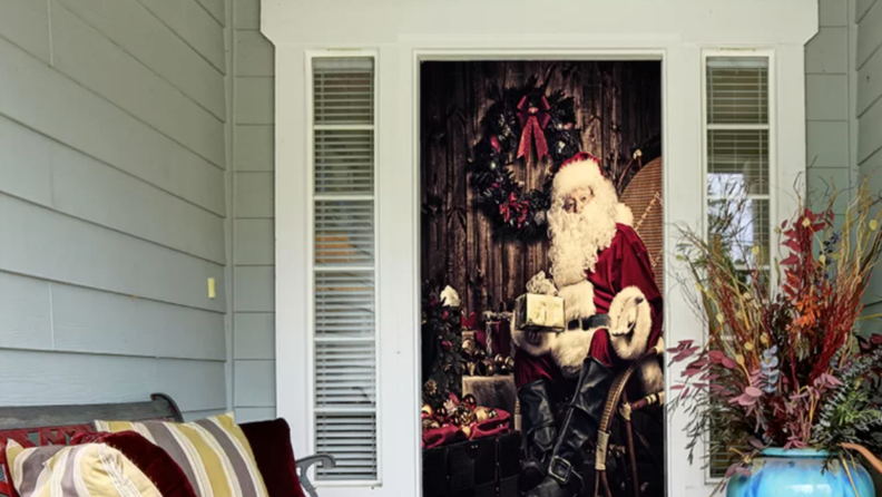 Santa Claus door mural on a front door in an entryway with a couch and potted plant