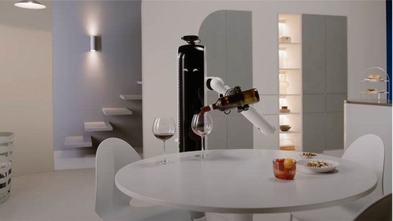 A slim, minimalistic robot (dubbed the Bot Handy) with crescent-shaped eyes and one mechanical arm pours a glass of wine.