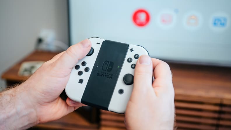 A hand holding a small gaming controller.