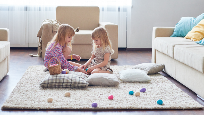 Sisters sit on the floor of the living room during an Easter egg hunt