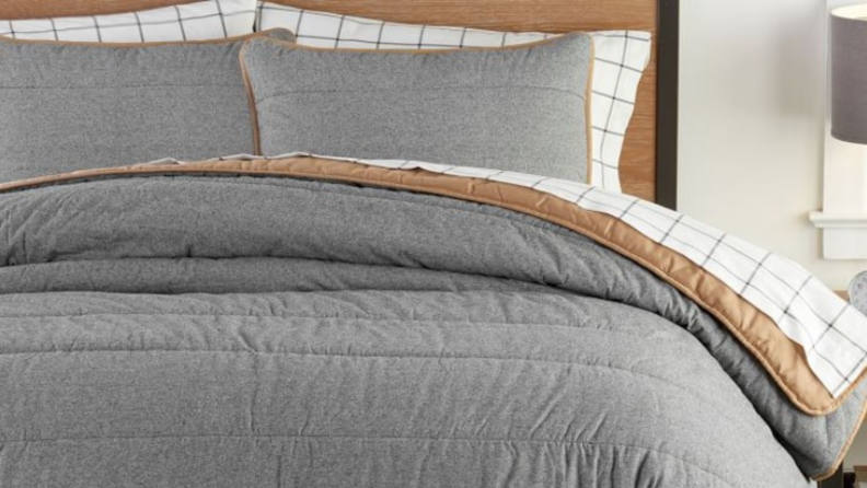 Close image of a gray Camden comforter with brown stripes on white on the interior laid on a bed with matching pillows.