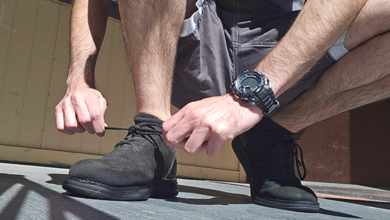Close-up of the author tying up a black pair of KnitFlex sneakers and getting ready to go for a run.