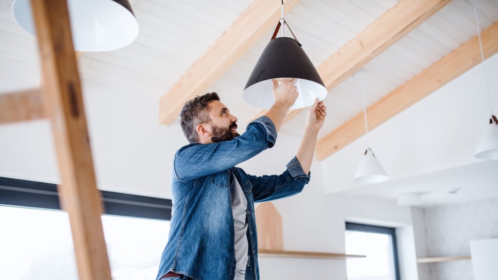 Man changing light bulb to save energy