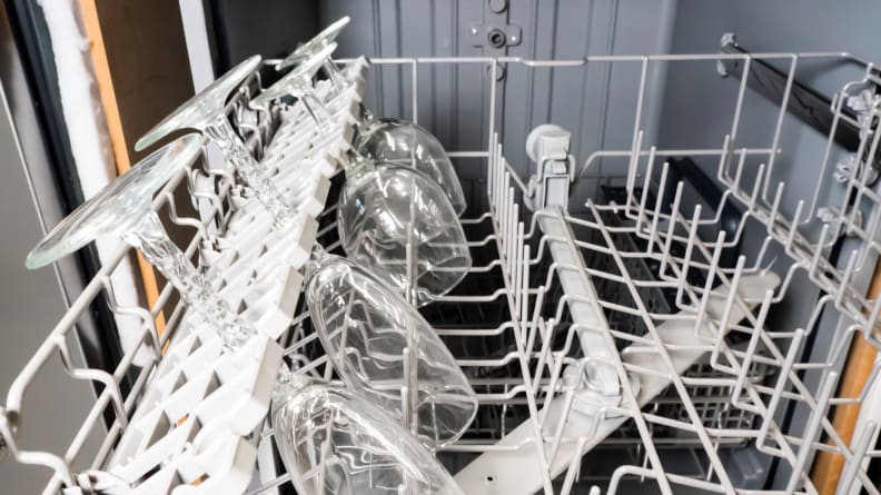 A close-up of the Samsung DW80R2031US dishwasher's upper rack, showcasing its stemware holders in action holding stemware.