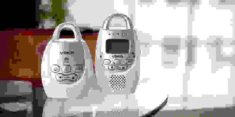 A VTech Safe & Sound DM221 baby audio monitor, base and receiver, on a glass tabletop.