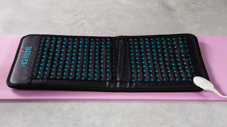 Le tapis Go Mat PEMF à dose plus élevée sur un tapis de yoga rose.