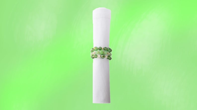A rolled up napkin in front of a green background.
