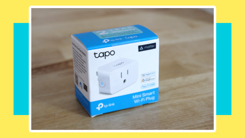 Box packaging for the Tapo Smart Plug Mini sitting on top of wooden surface.