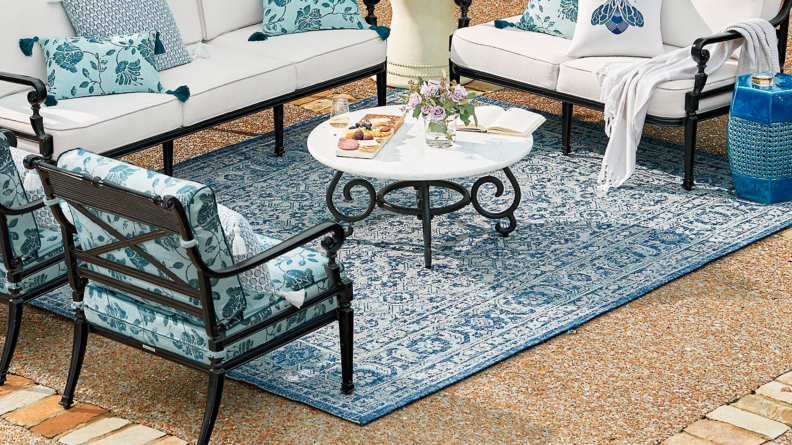 A blue outdoor rug on a patio.