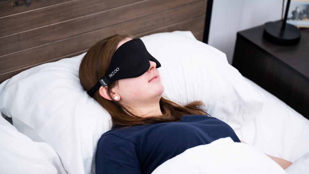 A woman sleeping with the Mzoo on her face.