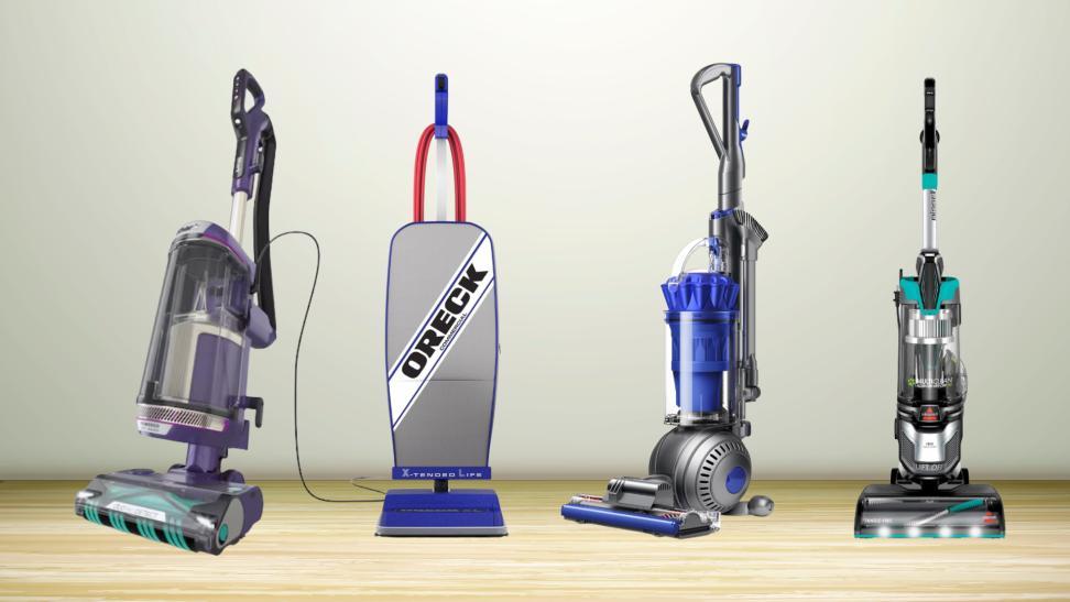 Four vacuums on a wooden floor in front of a wall