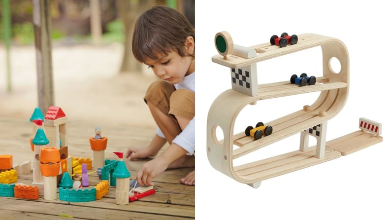 A child plays with a block set on one side of the frame. On the other, is a wooden track set.