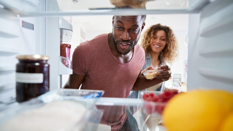 First-time homeowners looking in new refrigerator