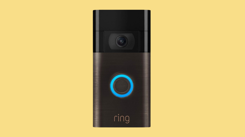 A bronze Ring doorbell on a yellow background.