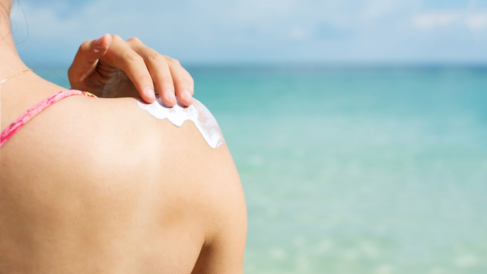 A woman applying sunscreen.