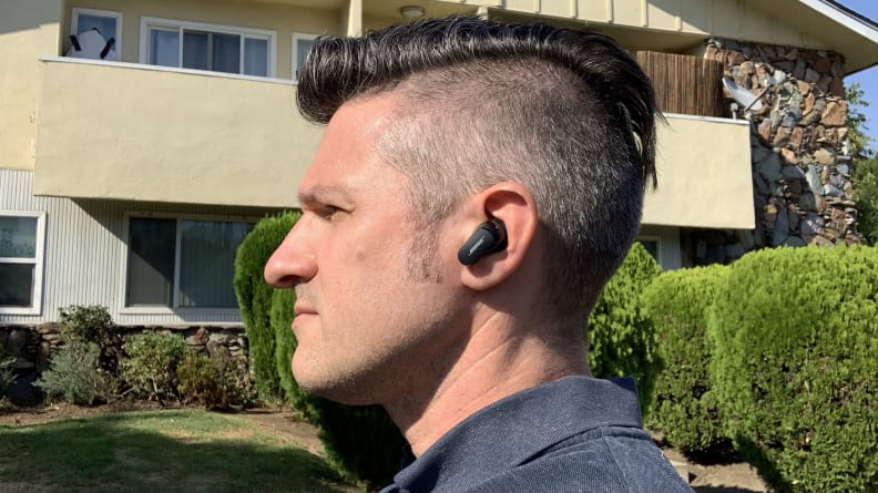 Profile view of author John Higgins with a Bose QuietComfort II earbud in his left ear.