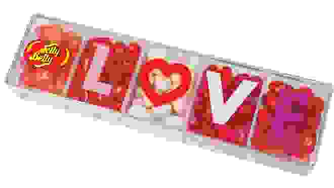 Assorted different colored jelly beans into rectangular container that reads "LOVE" on top
