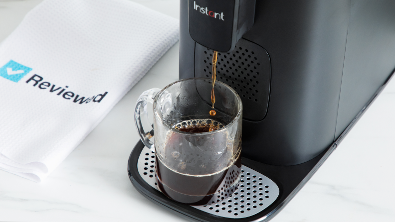 Cup of coffee being brewed under the Instant Dual Pod Plus Coffee Maker.