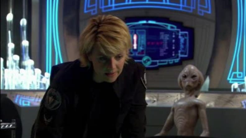 A still from 'Stargate SG-1' featuring a soldier and an alien.