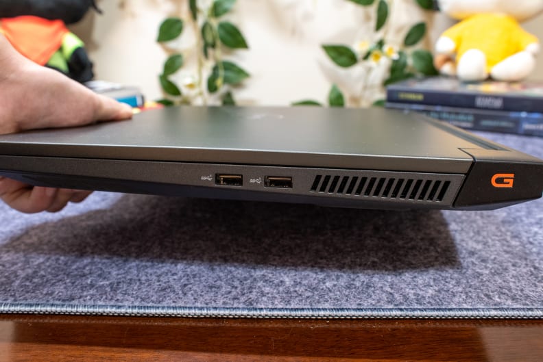 The side of a laptop showing connectivity ports and an air vent.