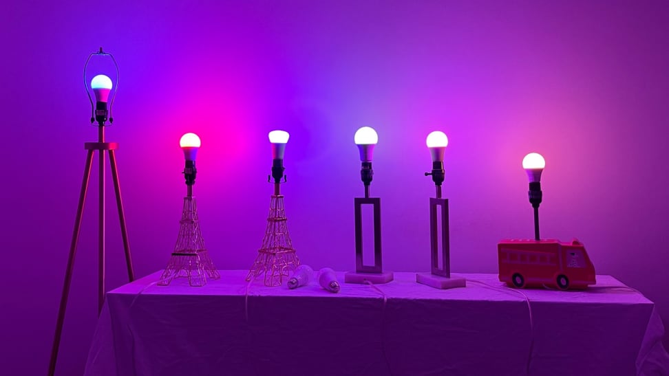 A dark room with six smart bulbs illuminated in various colors