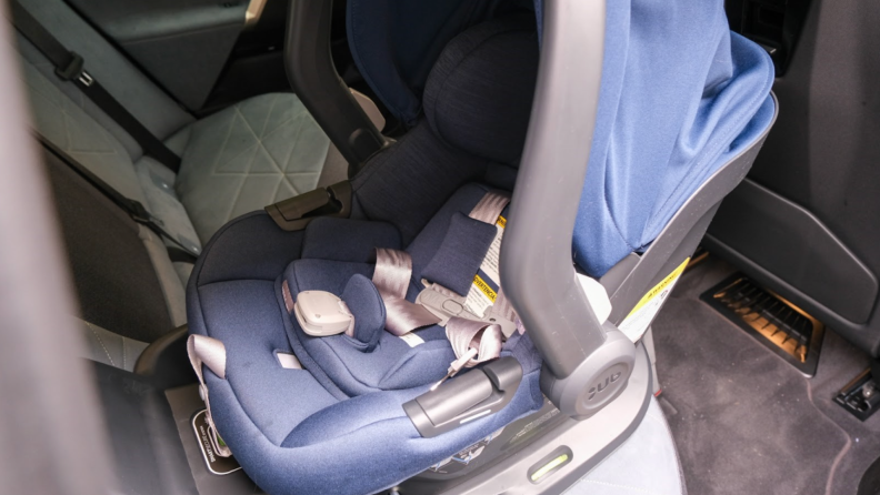 Navy blue Uppababy Mesa Max car seat strapped into backseat of car.
