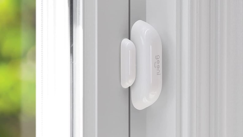 Capteur intelligent ovale blanc monté sur une porte blanche.