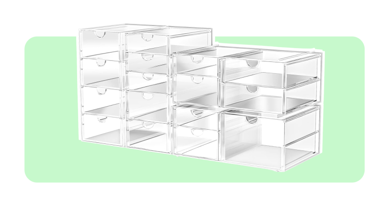 Multiple stacked empty clear storage bins in front of light green background.