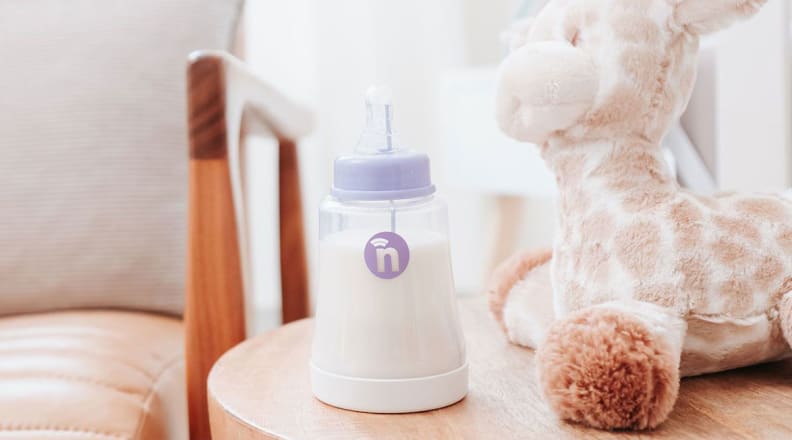 A bottle sitting on a table next to a stuffed animal.