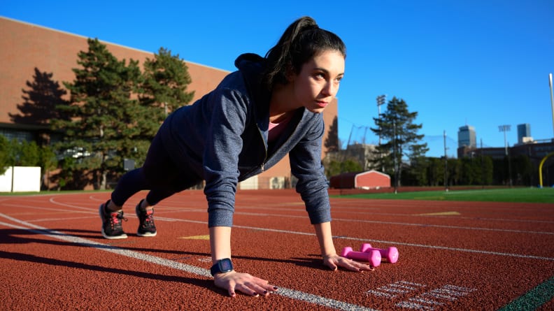woman wearing fitbit doing plank