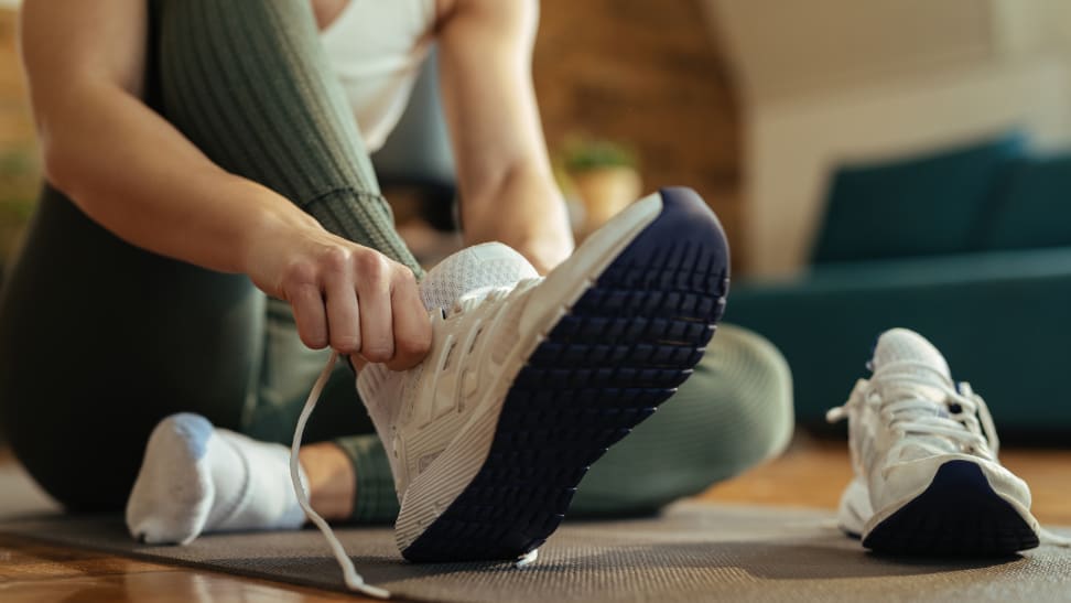 woman lacing up sneakers for exercise