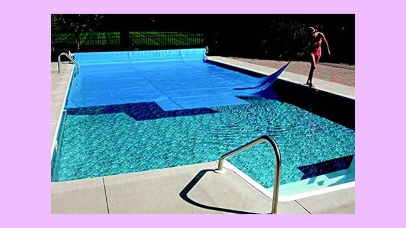 A woman drags a Pool Central blue pool cover across a swimming pool.