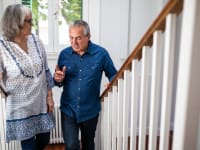 Two senior adults climb the stairs.