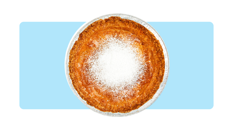 A Milk Bar Pie served in a round aluminum tray in front of a background.