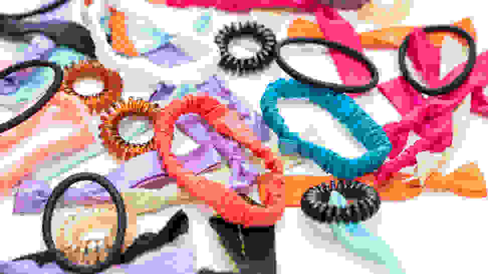 A smattering of colorful hair ties sprawled across a white surface.