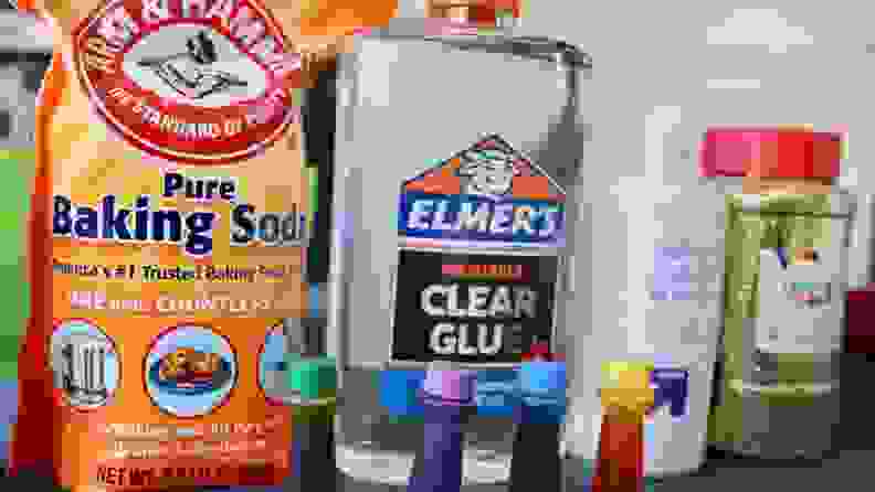 Arm & Hammer, Elmer's Glue, glitter, food coloring, and lens solution lined up.