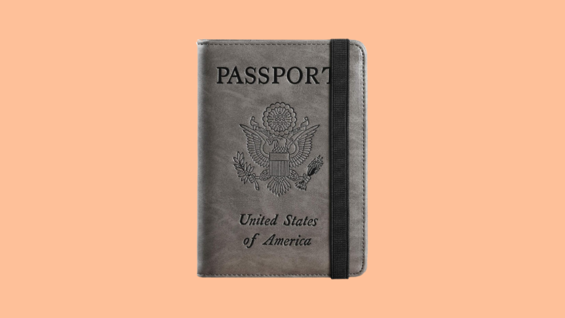 Gray passport holder with embossed eagle against orange background