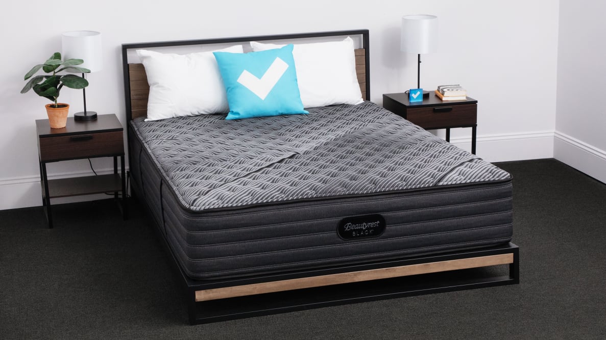 The Beautyrest Black Mattress with a bedroom set and a Reviewed logo pillow.