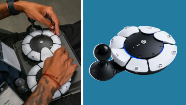 Set of two PlayStation Access Controllers sitting on top of person's lap next to single PlayStation Access Controller.