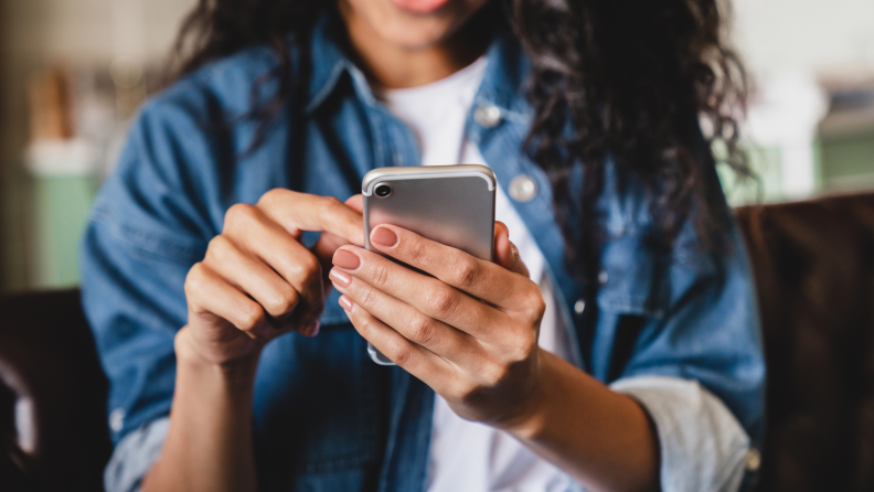 Person holding smart phone in hands indoor