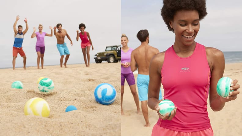 A group of people play with balls on a beach.