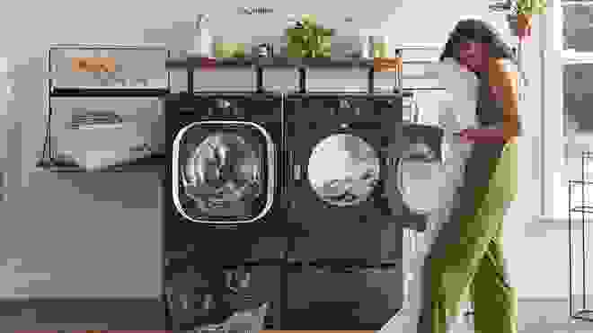 一个人从干衣机里卸下洗好的衣服。