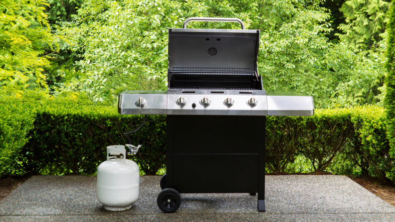 Propane grill on a concrete patio outside.